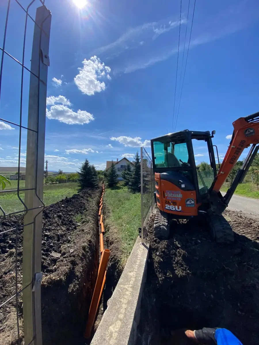 Miniexcavator Hitachi SomeTrans la un șanț pentru conducte
