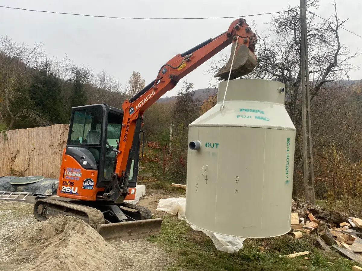 Miniexcavator Hitachi la manevrarea unui rezervor pentru instalații